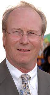 Jeanne Bonnaire's father William hurt wearing a brown suit.
